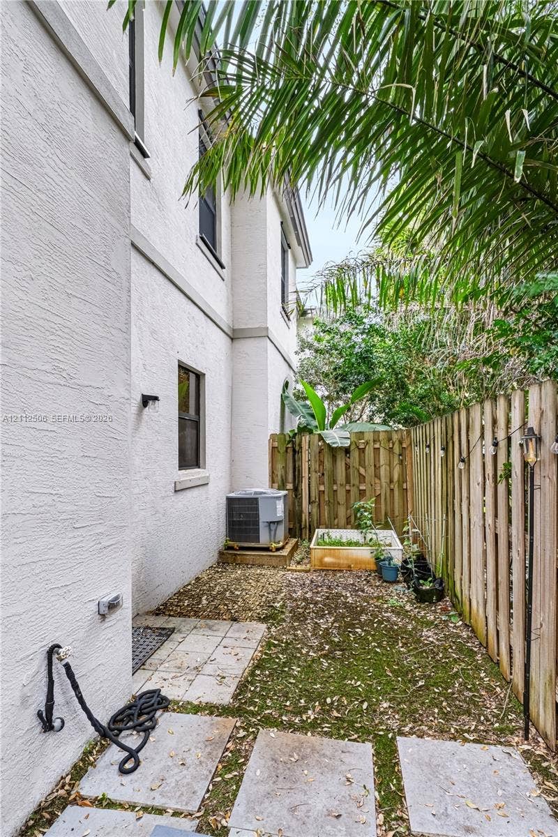 538 SW 19th Terrace, Fort Lauderdale, Fort Lauderdale, FL 33312 Stucco exterior side yard featuring concrete paver stones, a wooden privacy fence, and native landscaping