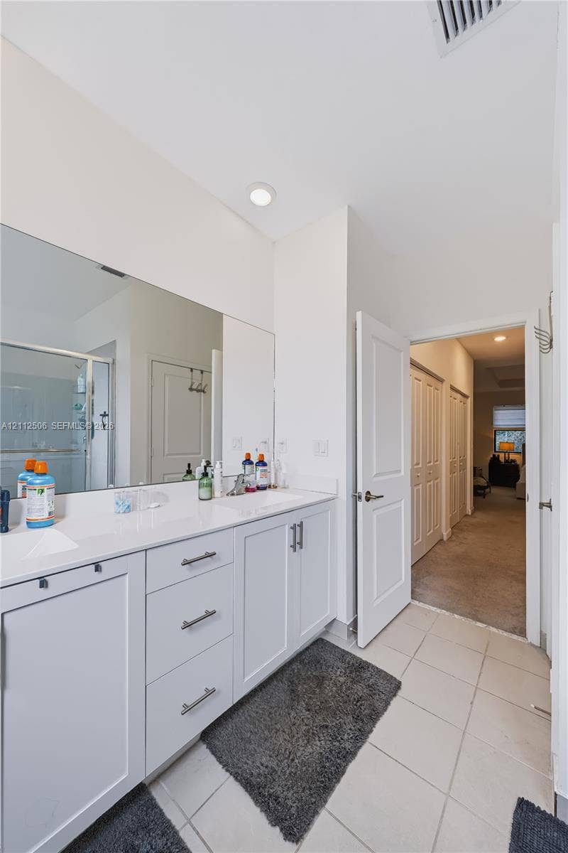 538 SW 19th Terrace, Fort Lauderdale, Fort Lauderdale, FL 33312 Bathroom featuring a dual-sink vanity with white cabinetry, solid-surface countertops, polished chrome fixtures, and a large-format vanity mirror