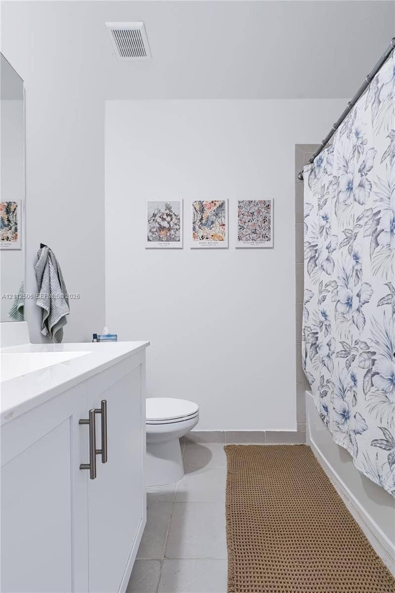 538 SW 19th Terrace, Fort Lauderdale, Fort Lauderdale, FL 33312 Bathroom featuring a white vanity cabinet with a stone-finish countertop, an integrated rectangular sink, dual-handle hardware, and a tub-shower combination with ceramic tile surround