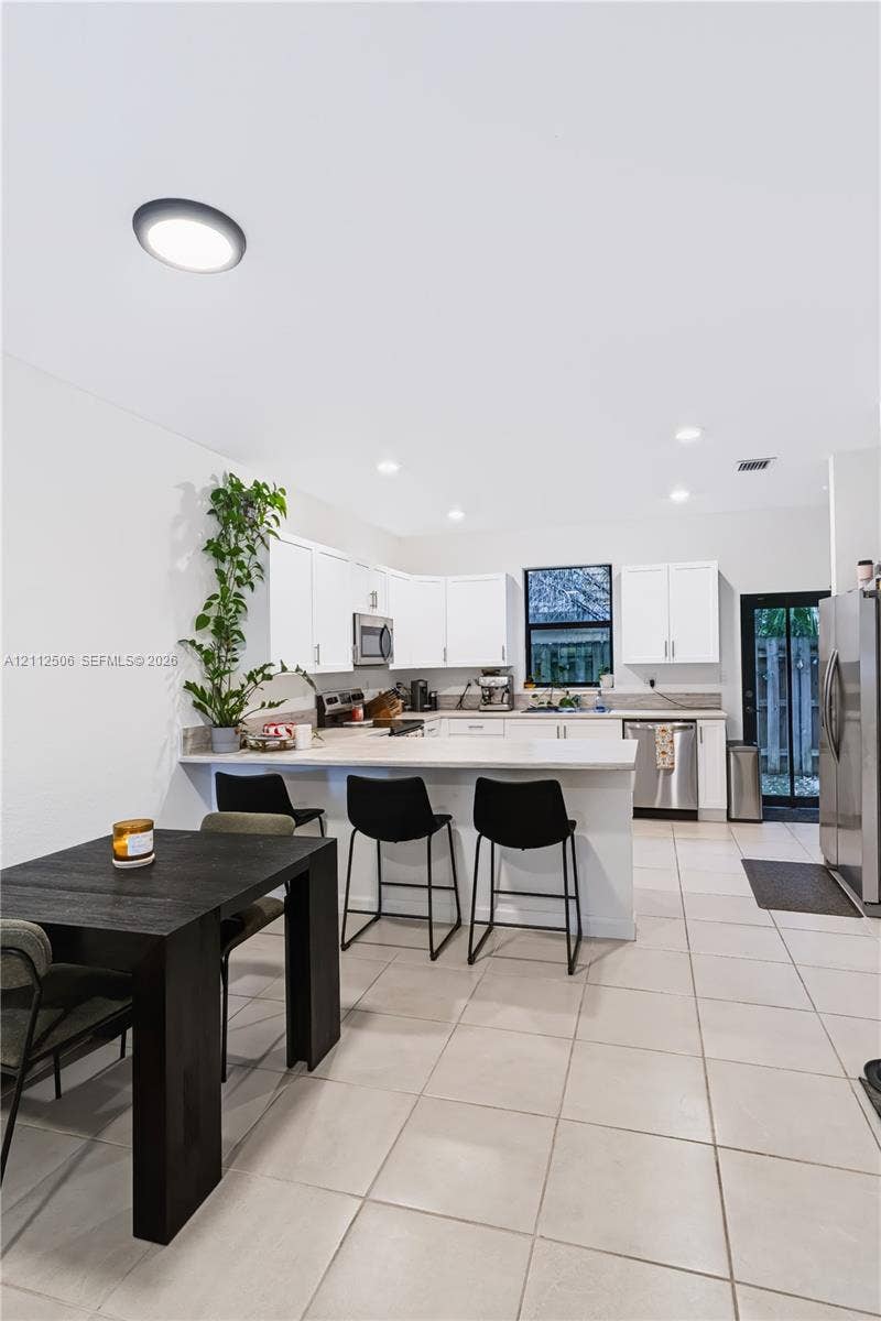 538 SW 19th Terrace, Fort Lauderdale, Fort Lauderdale, FL 33312 Kitchen featuring white cabinetry, solid-surface countertops, tile flooring, stainless steel appliances, and recessed lighting