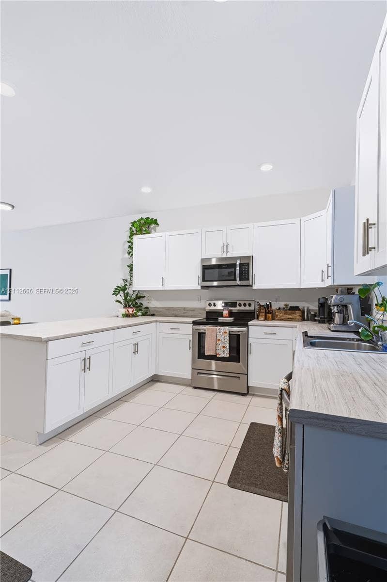 538 SW 19th Terrace, Fort Lauderdale, Fort Lauderdale, FL 33312 Kitchen featuring white shaker-style cabinetry, stainless steel appliances, light-toned countertop surfaces, and large-format tile flooring