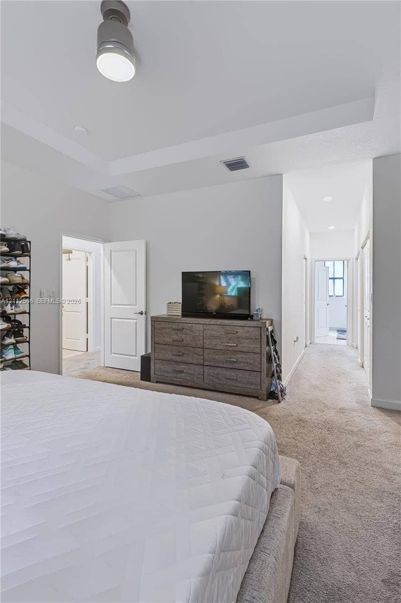 538 SW 19th Terrace, Fort Lauderdale, Fort Lauderdale, FL 33312 Interior room featuring a tray ceiling, wall-to-wall carpeting, and a modern cylinder-style ceiling light fixture