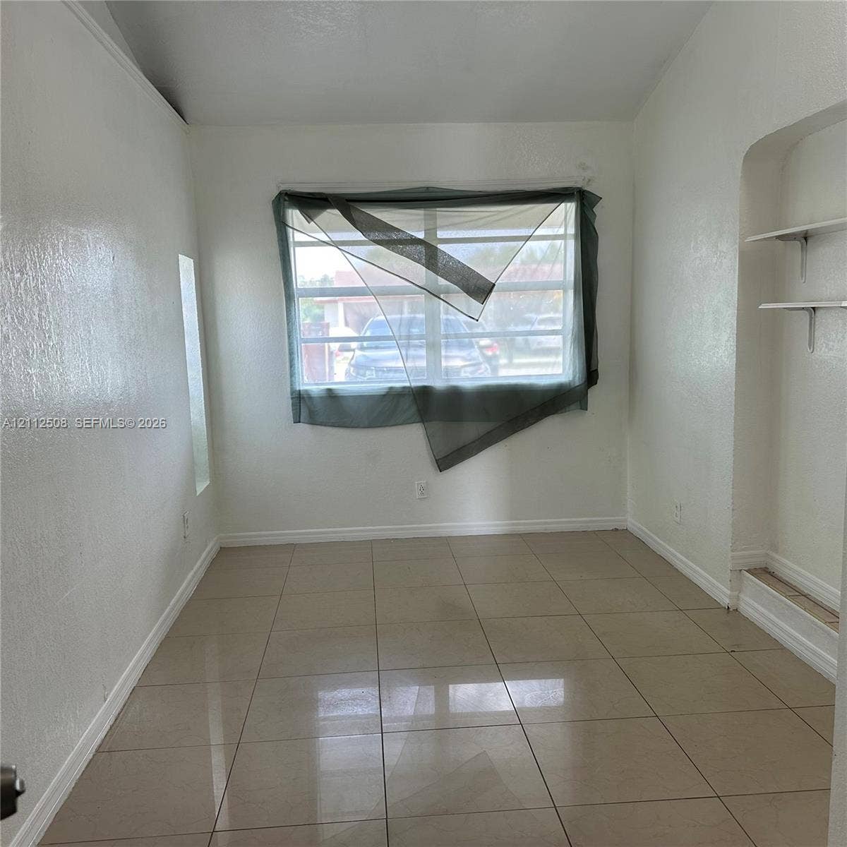 6432 Flagler Street, #1, Hollywood, Hollywood, FL 33023 Neutral-toned tiled flooring, large window with horizontal muntins, and recessed arched wall shelving