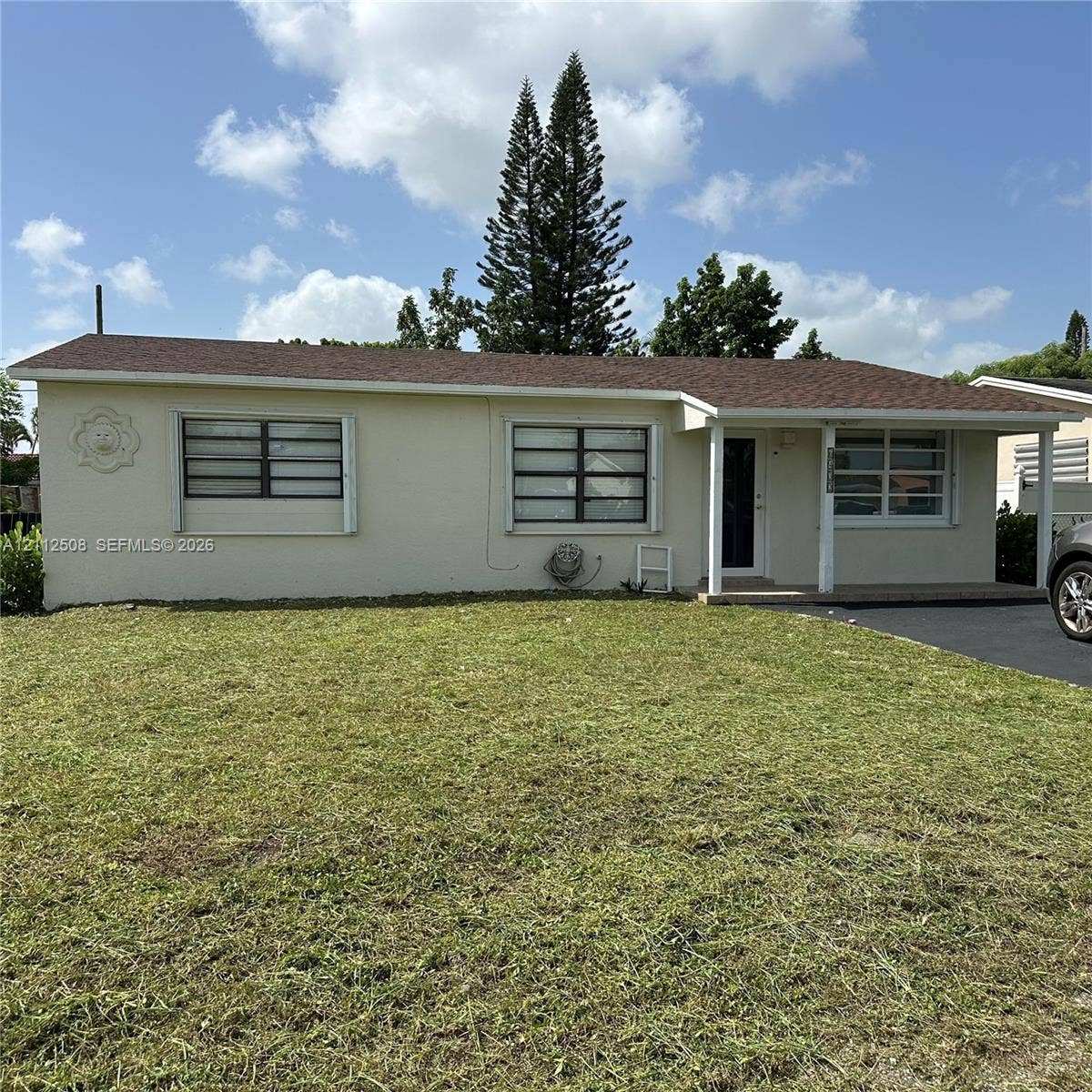 6432 Flagler Street, #1, Hollywood, Hollywood, FL 33023 Single-story residence featuring a light-toned stucco exterior, shingled roof, covered front porch, and asphalt driveway