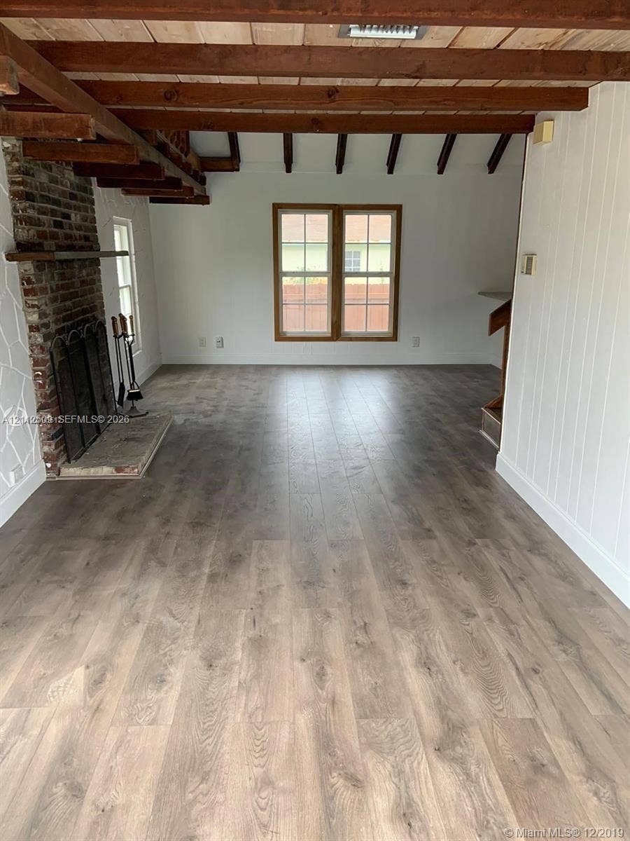 215 4th Street, #1, Jupiter, Jupiter, FL 33458 Exposed wood ceiling beams, floor-to-ceiling brick fireplace with a stone hearth, and wood-finish flooring