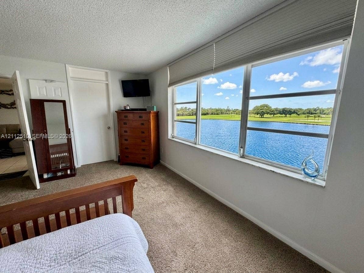 9250 W Bay Harbor Drive, #4A, Bay Harbor Islands, FL 33154 Expansive window featuring horizontal blinds, neutral wall-to-wall carpeting, and water scenery