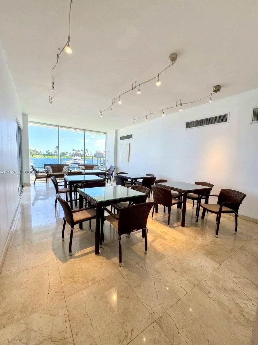 9250 W Bay Harbor Drive, #4A, Bay Harbor Islands, FL 33154 Open-concept interior featuring polished stone flooring, floor-to-ceiling windows, and multi-track ceiling lighting