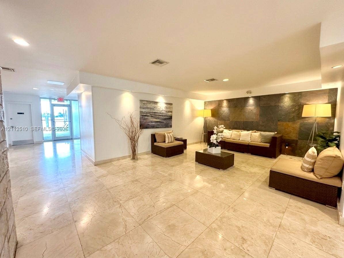 9250 W Bay Harbor Drive, #4A, Bay Harbor Islands, FL 33154 Large-format tile flooring, textured stone accent wall, and recessed ceiling lighting