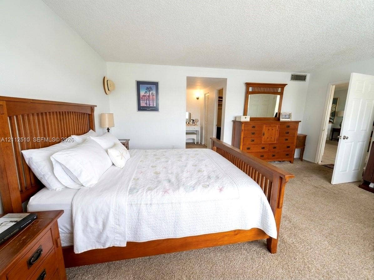 9250 W Bay Harbor Drive, #4A, Bay Harbor Islands, FL 33154 Bedroom featuring neutral wall-to-wall carpeting and a multi-panel door