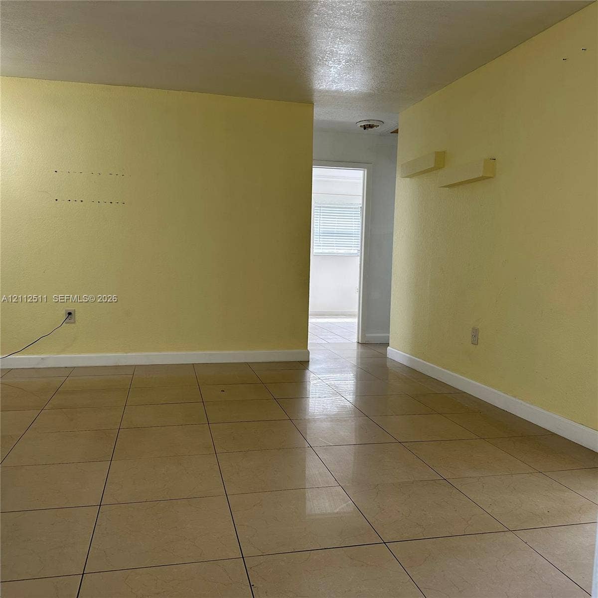 Interior space featuring large-format neutral tile flooring and smooth-finish walls