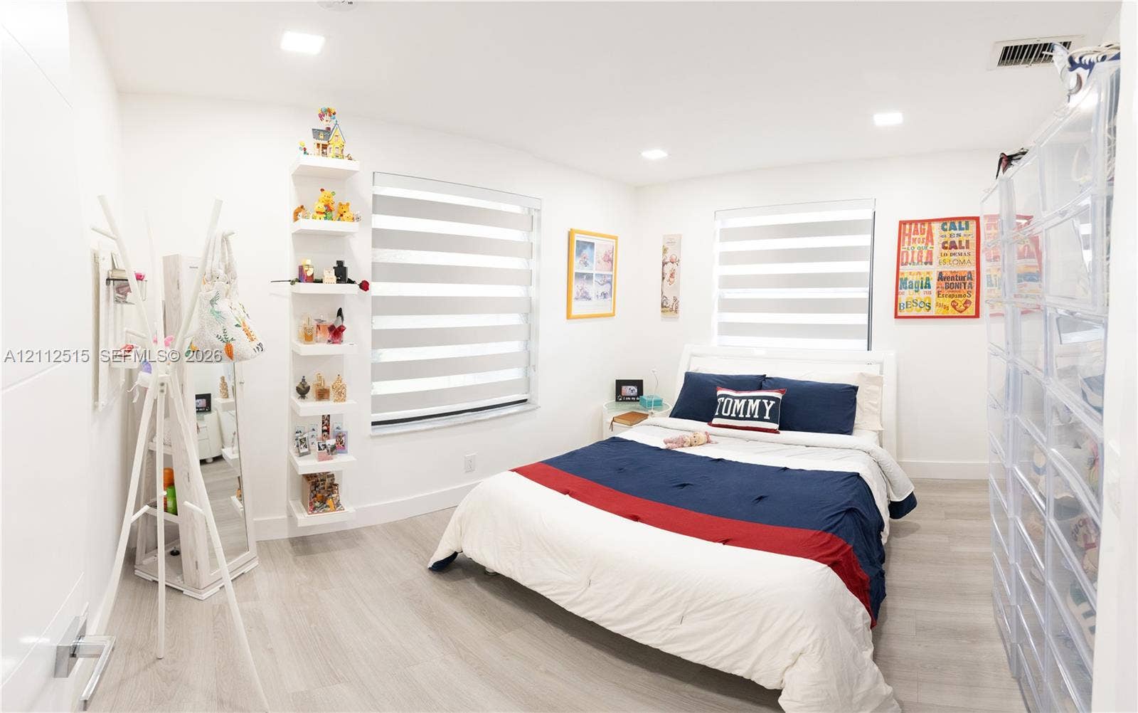 Hallandale Beach, FL 33009 Interior room featuring wood-finish flooring, recessed lighting, dual windows with fitted light-filtering shades, and custom built-in wall shelving