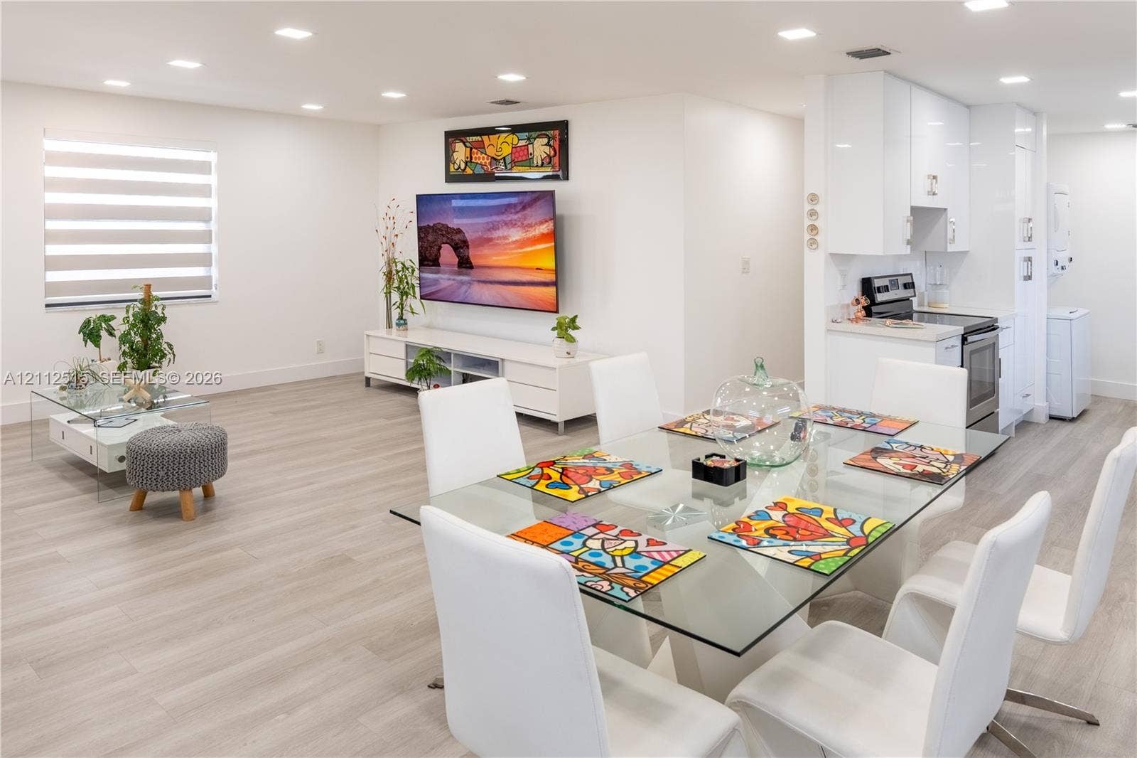 Hallandale Beach, FL 33009 Open-concept interior featuring wood-finish flooring, recessed lighting, and sleek white cabinetry