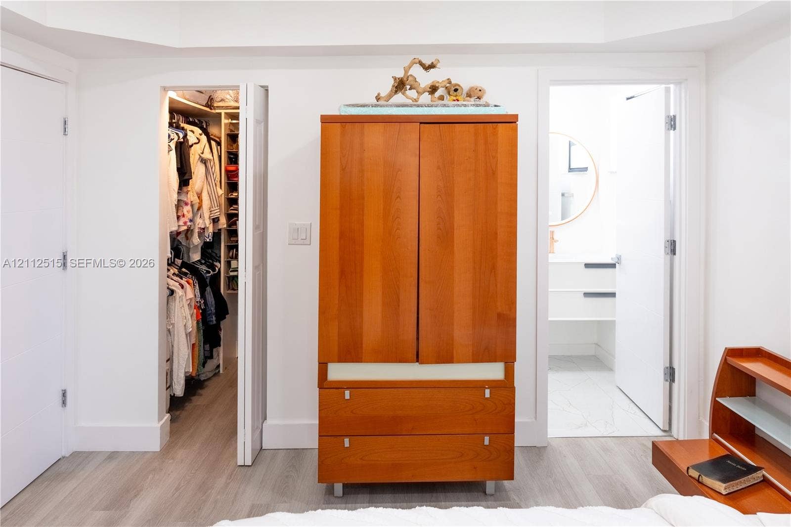 Hallandale Beach, FL 33009 Walk-in closet with built-in shelving, wood-finish flooring, and tray ceiling