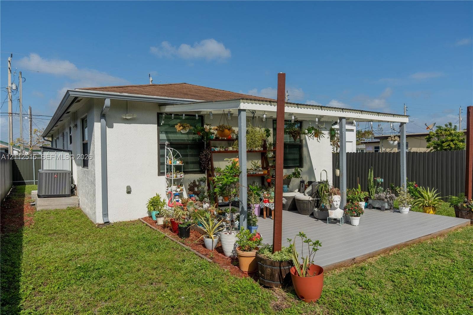 Hallandale Beach, FL 33009 Exterior space featuring a covered deck, fenced perimeter, and dedicated ground-level HVAC unit