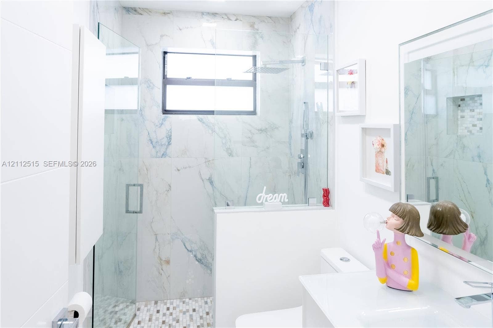 Hallandale Beach, FL 33009 Walk-in shower featuring floor-to-ceiling stone-finish tile, glass enclosure, recessed wall niche, and rainfall showerhead