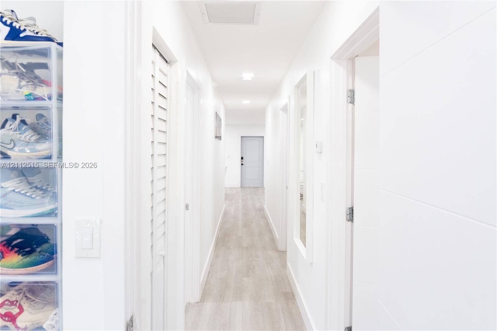 Hallandale Beach, FL 33009 Hallway featuring wood-finish flooring, recessed lighting, and white louvered doors