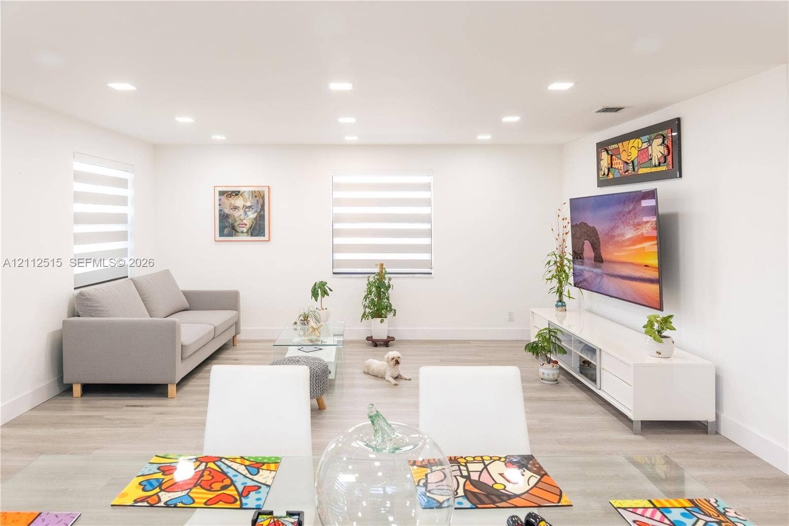 Hallandale Beach, FL 33009 Open-concept interior featuring wood-finish flooring, recessed lighting, and dual windows with fitted shades