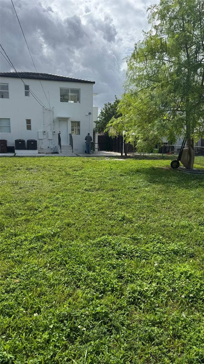351 E 14th Street, #353, Hialeah, Hialeah, FL 33010 Expansive backyard featuring a large grass lawn, mature trees, and a concrete patio area