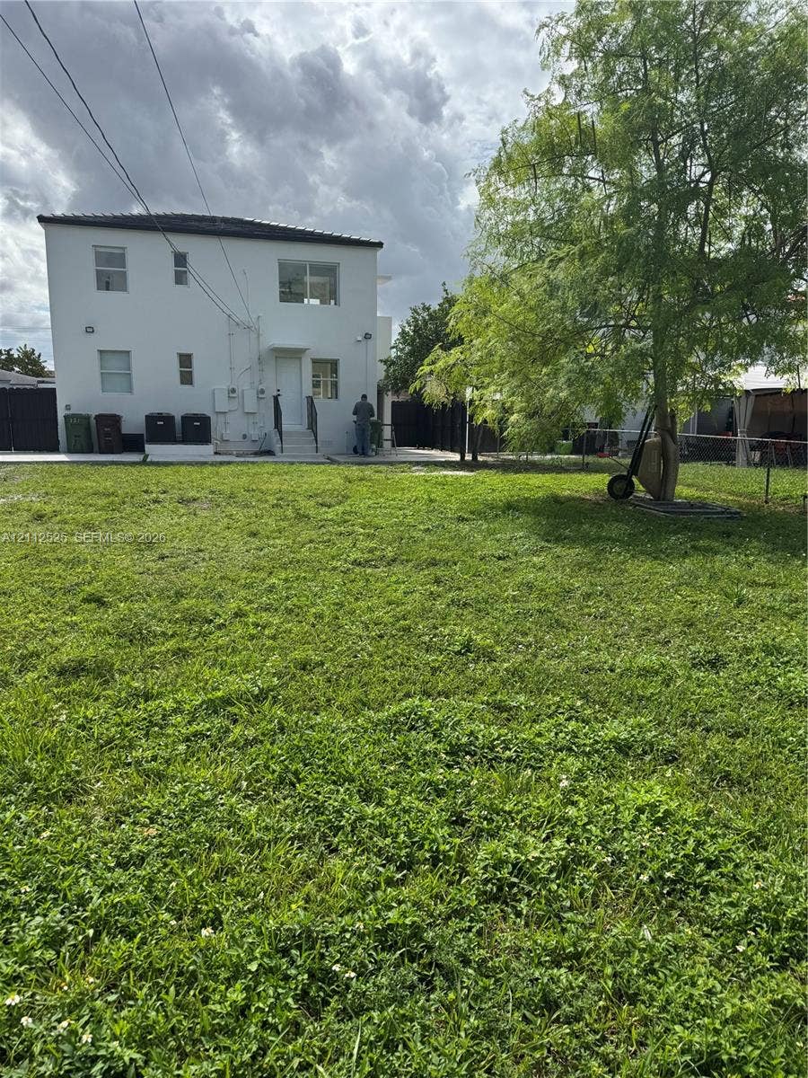 351 E 14th Street, #353, Hialeah, Hialeah, FL 33010 Expansive backyard featuring a grass lawn, mature tree, perimeter fencing, and a concrete patio