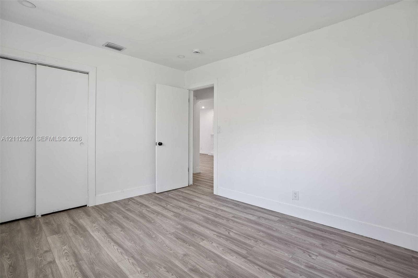 2517 Polk Street, Hollywood, Hollywood, FL 33020 Room featuring wood-finish flooring, sliding closet doors, and neutral wall paint
