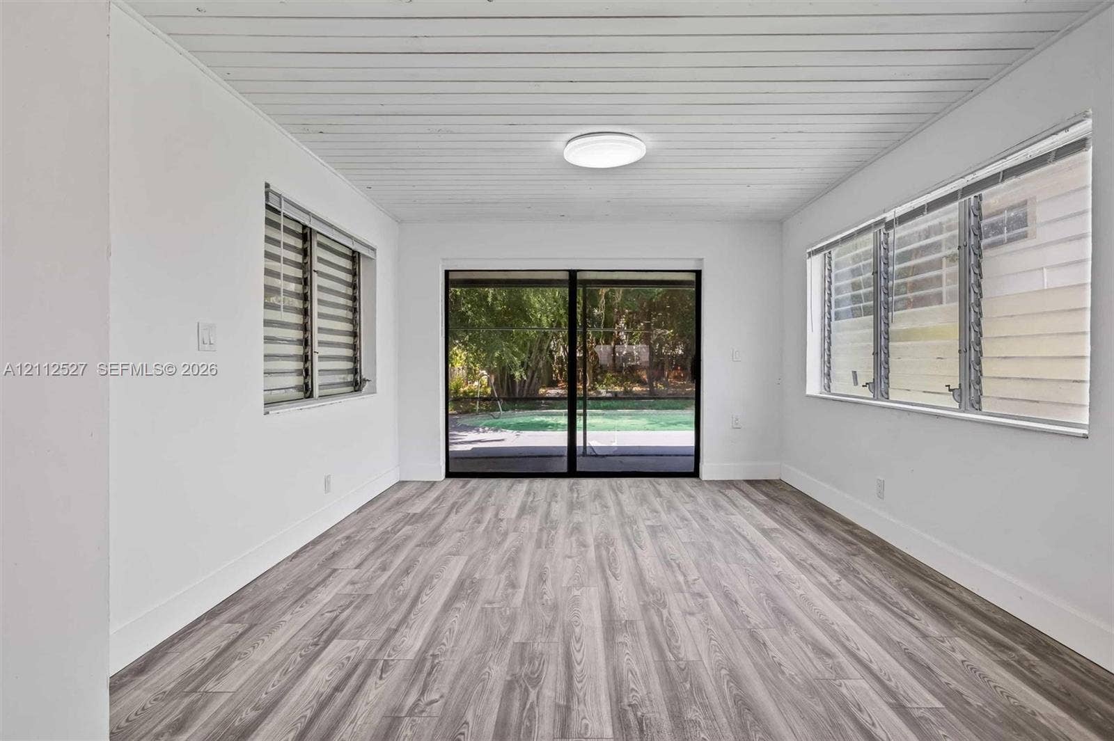 2517 Polk Street, Hollywood, Hollywood, FL 33020 Wood-finish flooring, planked ceiling, sliding glass patio doors, and multi-pane windows with integrated blinds