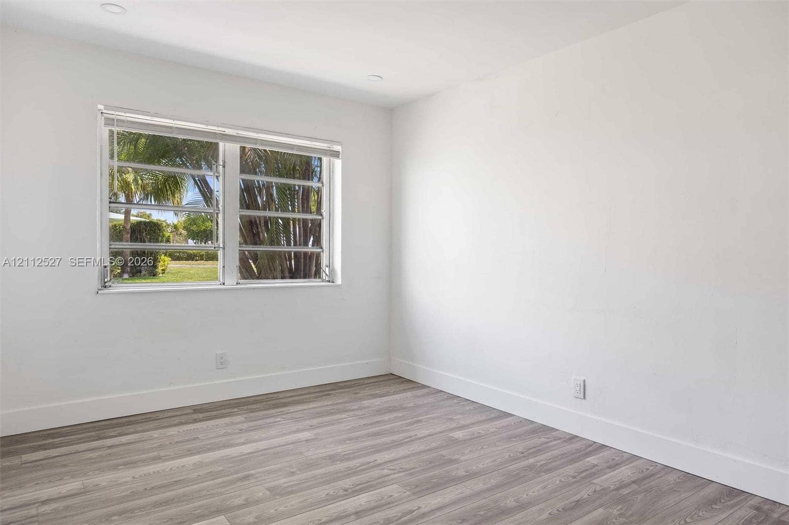 2517 Polk Street, Hollywood, Hollywood, FL 33020 Room interior featuring wood-finish flooring, white walls, and a horizontal louvered window