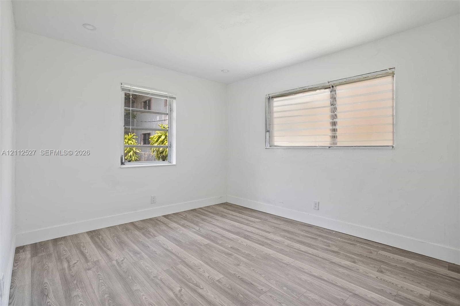 2517 Polk Street, Hollywood, Hollywood, FL 33020 Interior space featuring wood-finish flooring, white walls, recessed ceiling lighting, and windows equipped with fitted blinds