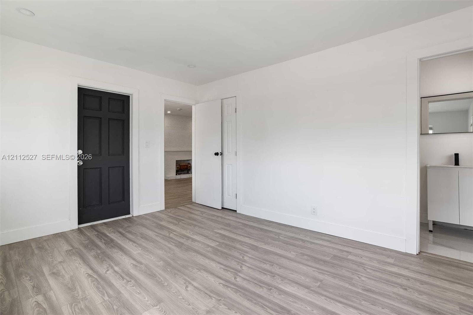 2517 Polk Street, Hollywood, Hollywood, FL 33020 Interior space featuring wood-finish flooring, a dark six-panel door, recessed lighting, and a white vanity with a metallic faucet