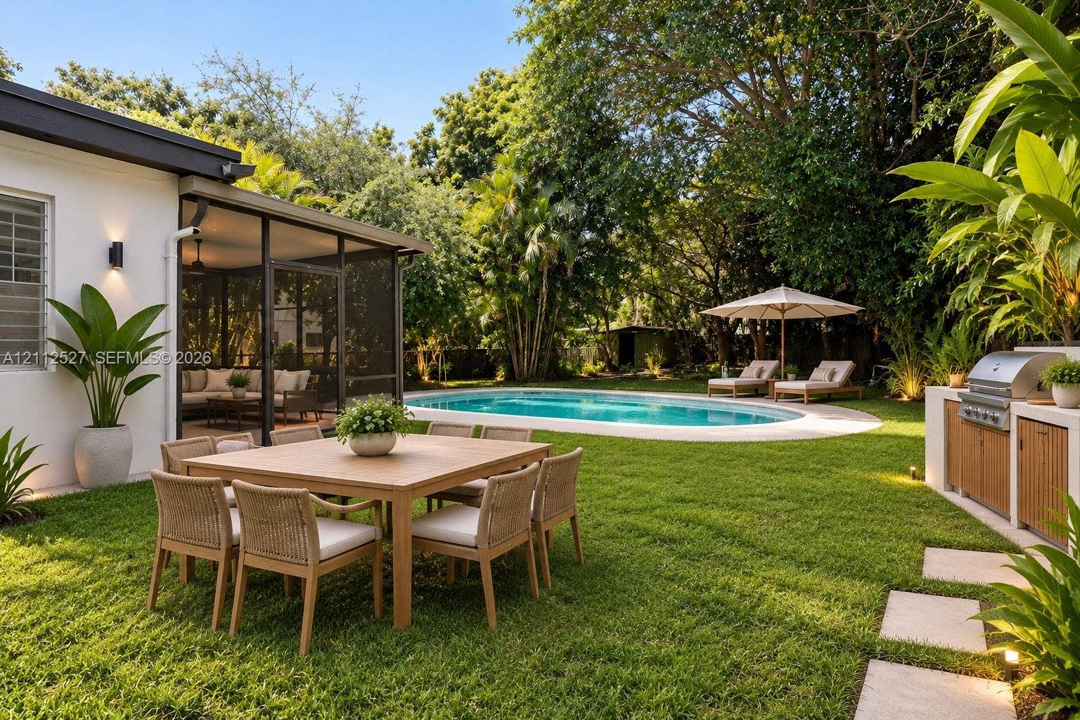 2517 Polk Street, Hollywood, Hollywood, FL 33020 Screened patio, swimming pool with concrete surround, built-in outdoor kitchen with stainless steel grill, and manicured lawn