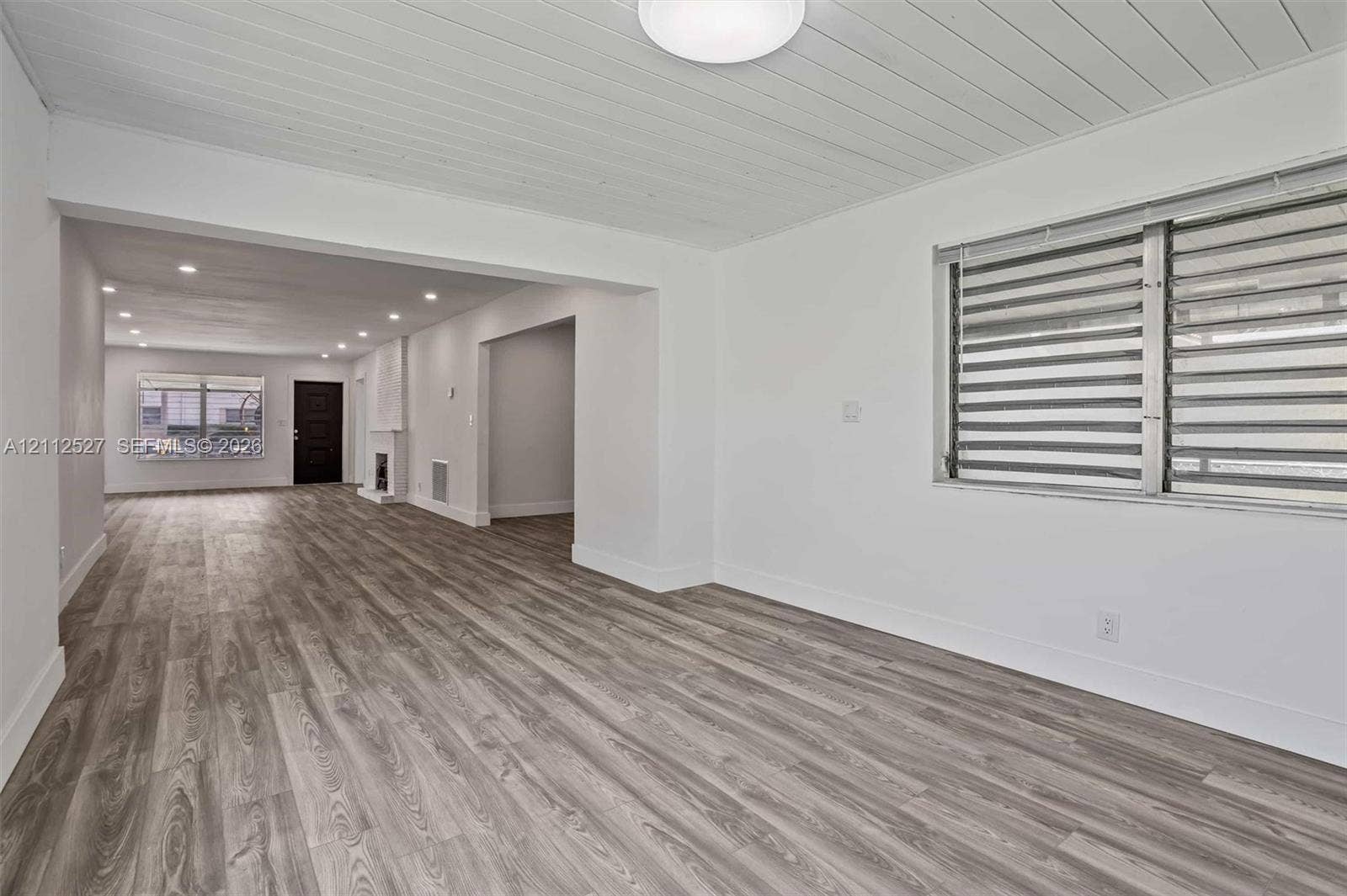 2517 Polk Street, Hollywood, Hollywood, FL 33020 Plank-style wood-finish flooring, white shiplap ceiling, recessed lighting, and horizontal window blinds