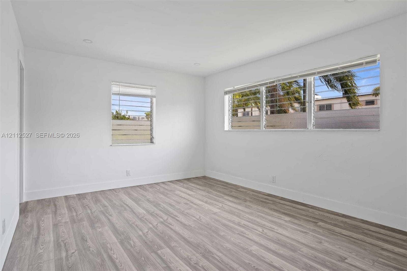 2517 Polk Street, Hollywood, Hollywood, FL 33020 Bright interior featuring wood-finish flooring, recessed lighting, and multiple horizontal windows with integrated security bars