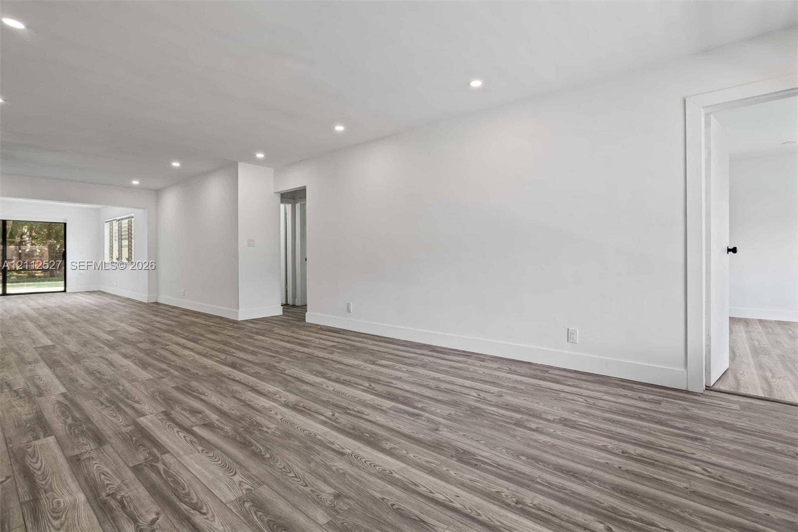 2517 Polk Street, Hollywood, Hollywood, FL 33020 Neutral-toned interior featuring wood-finish flooring, recessed lighting, and sliding glass door access to the exterior