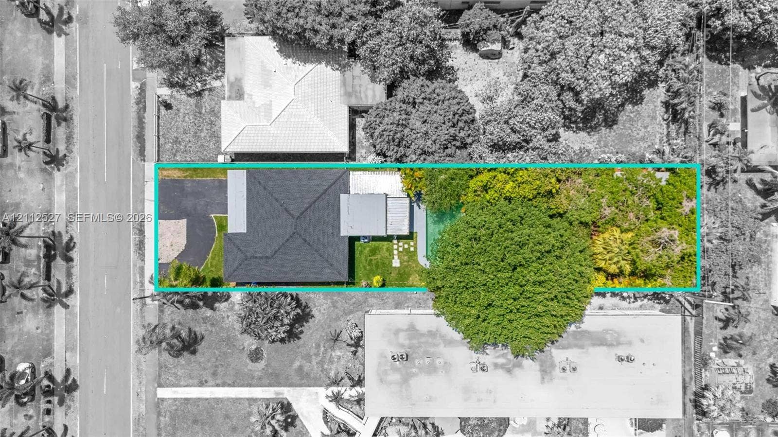 2517 Polk Street, Hollywood, Hollywood, FL 33020 Aerial view of property featuring a dark-toned shingle roof, asphalt driveway, manicured lawn, stone-paver walkway, and mature landscaping