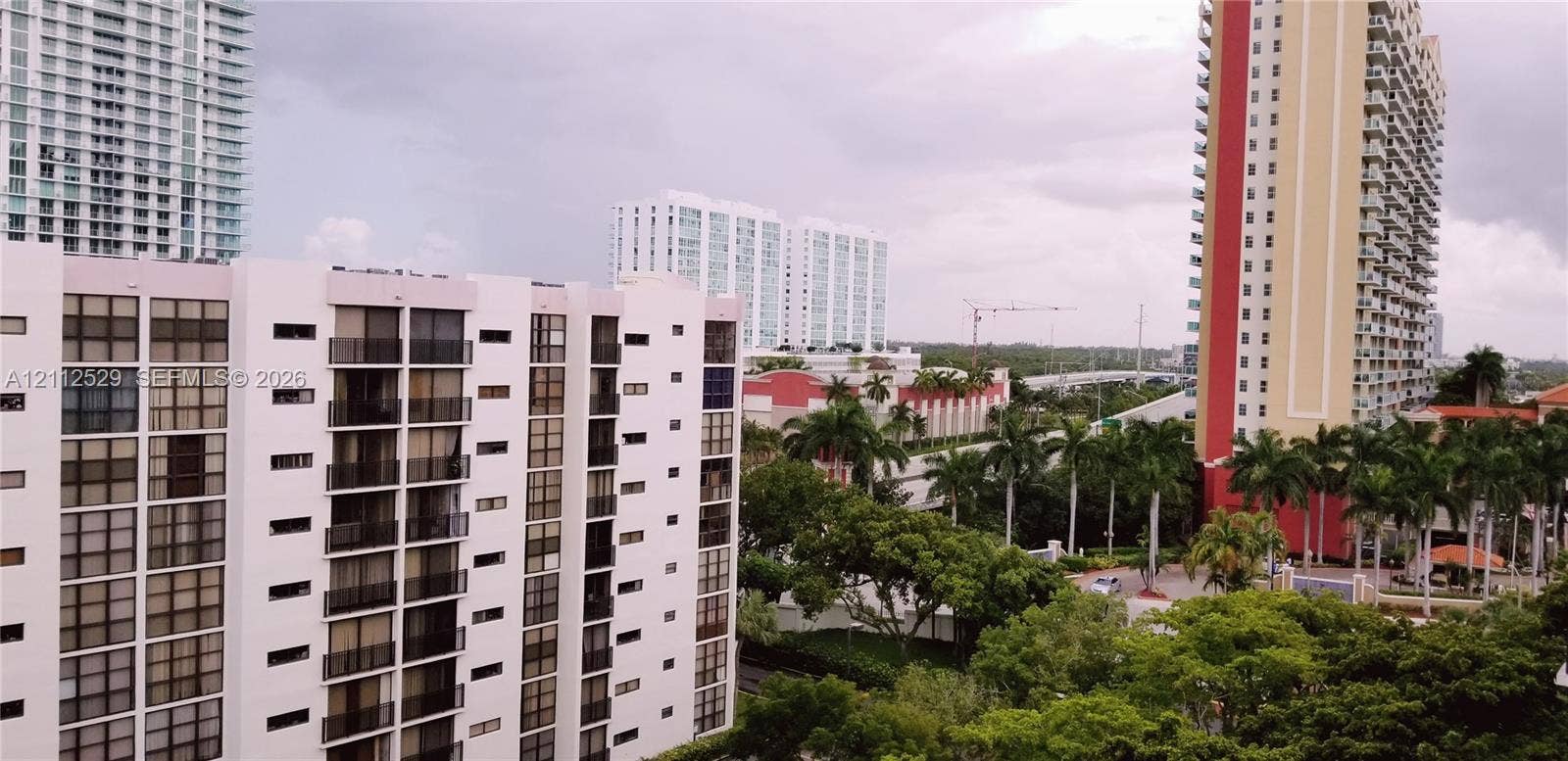 17021 N Bay Road, #101, Sunny Isles Beach, Sunny Isles Beach, FL 33160 High-rise urban landscape featuring multi-story residential towers, balcony structures, and mature palm trees