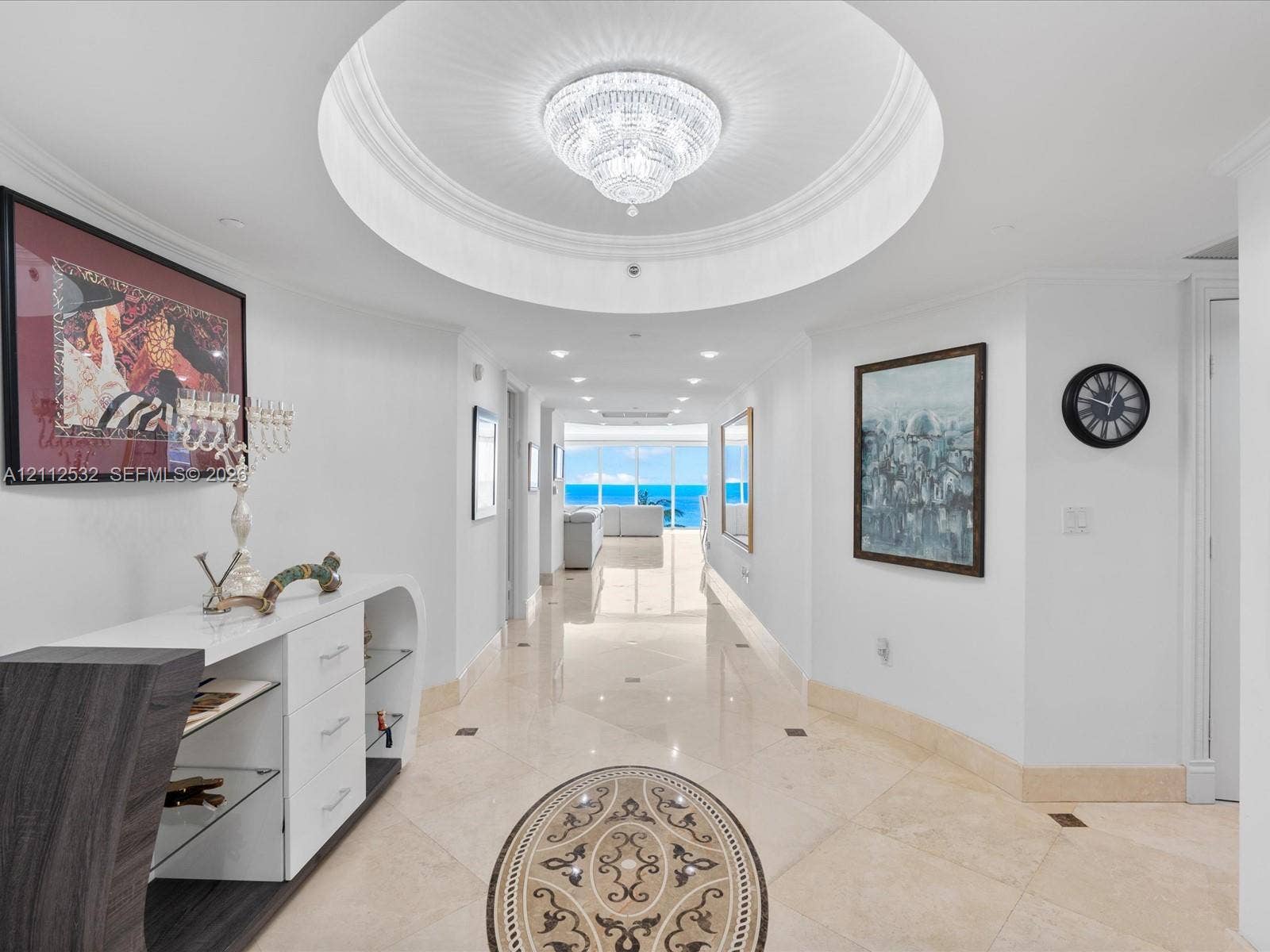 18911 Collins Avenue, #601, Sunny Isles Beach, FL 33160 Foyer featuring a recessed circular tray ceiling, crystal chandelier, polished stone flooring with decorative inlay, and recessed lighting