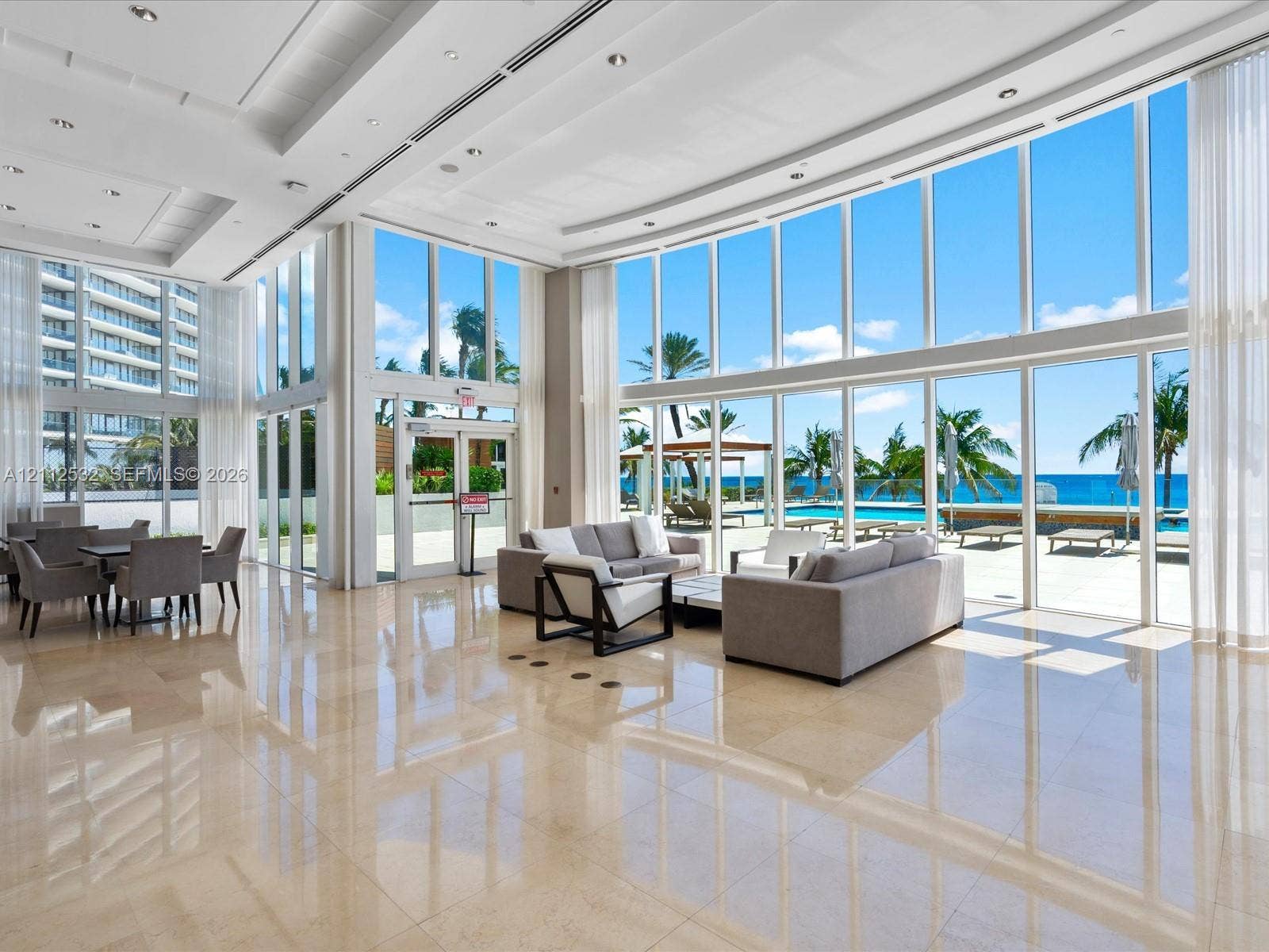 18911 Collins Avenue, #601, Sunny Isles Beach, FL 33160 Floor-to-ceiling glass windows, polished stone flooring, recessed ceiling lighting, and expansive structural columns