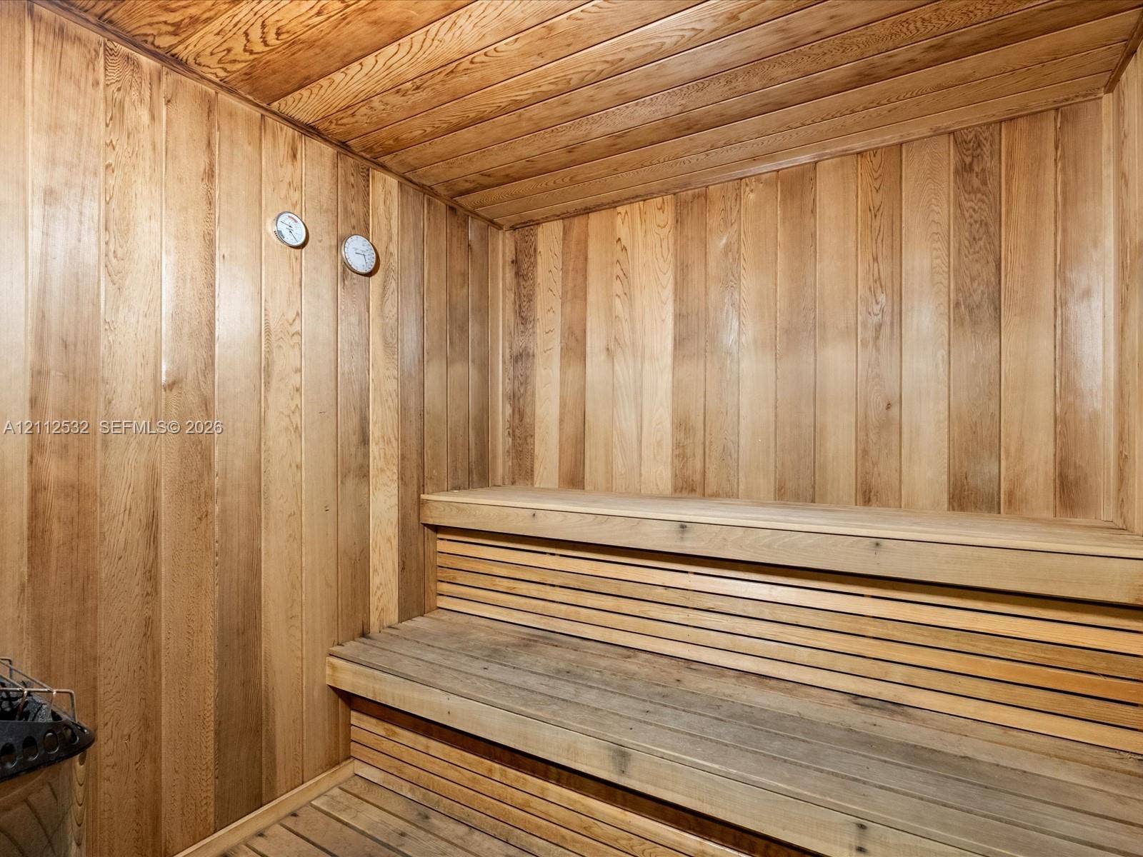 18911 Collins Avenue, #601, Sunny Isles Beach, FL 33160 Sauna featuring natural wood-paneled walls and ceiling, tiered wood benches, and integrated wall-mounted analog gauges
