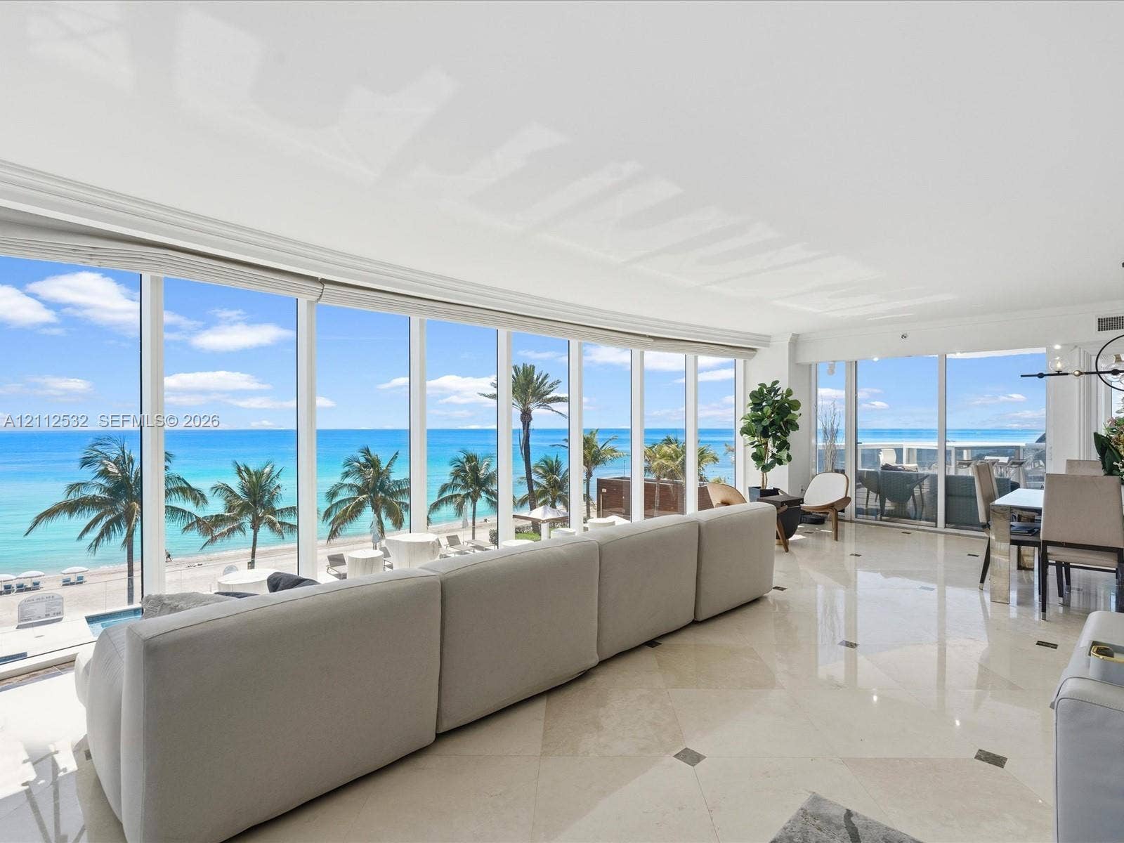 18911 Collins Avenue, #601, Sunny Isles Beach, FL 33160 Floor-to-ceiling windows, polished stone tile flooring with decorative inlay, and coastal scenery