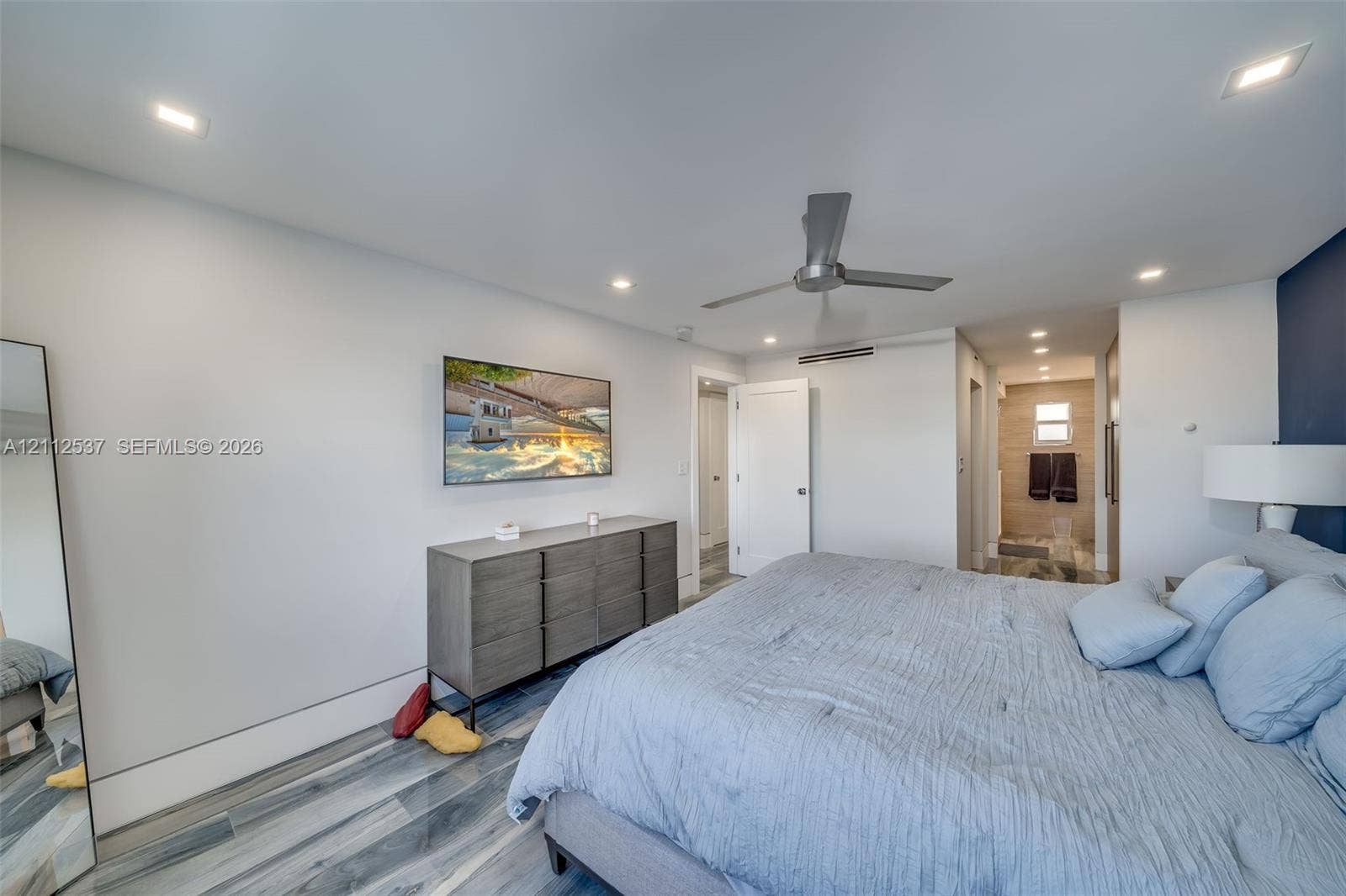 2871 N Ocean Boulevard, #R360, Boca Raton, FL 33431 Neutral-toned room featuring wood-finish flooring, recessed LED ceiling lighting, a brushed metal ceiling fan, and an accent wall