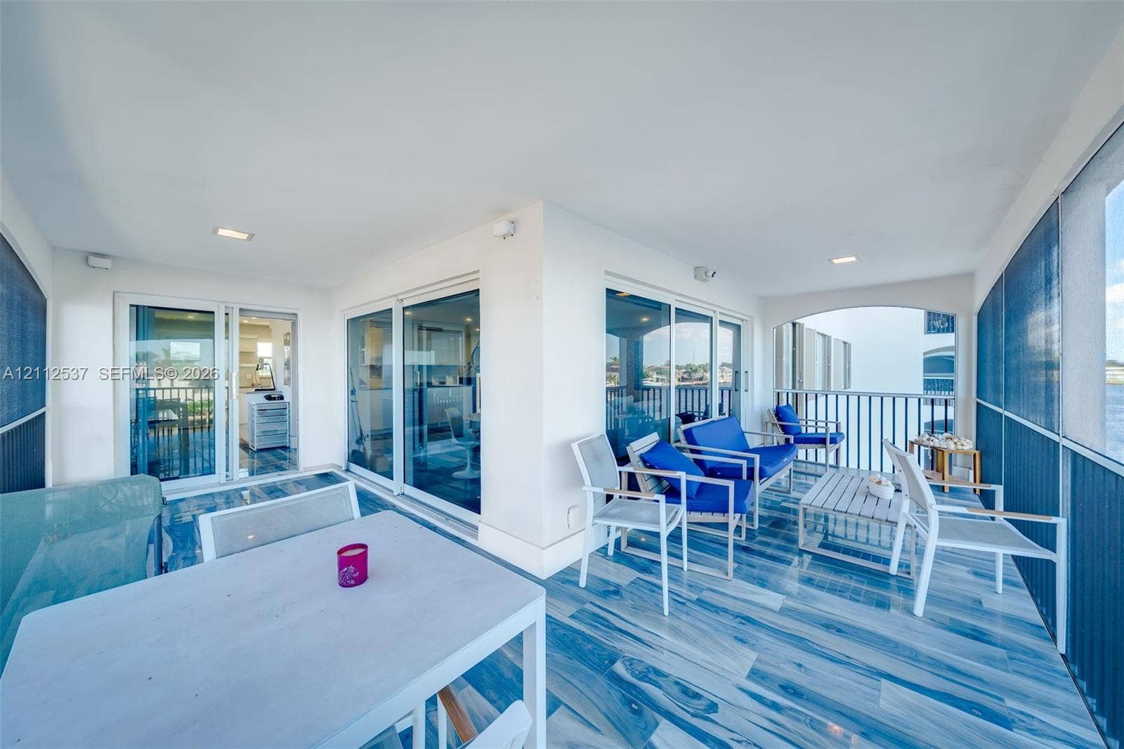 2871 N Ocean Boulevard, #R360, Boca Raton, FL 33431 Covered balcony featuring multi-panel glass sliding doors, tiled flooring, recessed lighting, and metal railing