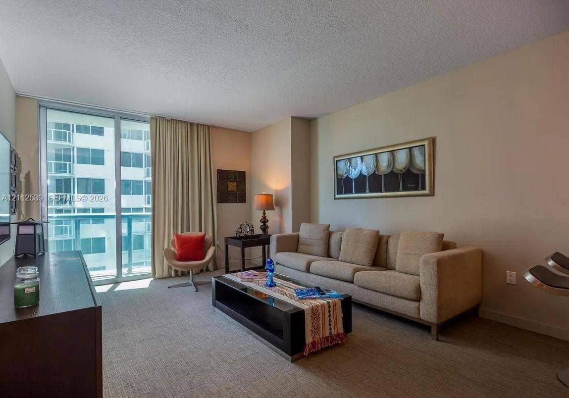 17315 Collins Avenue, #705, Sunny Isles Beach, FL 33160 Floor-to-ceiling sliding glass door providing natural light and access to the exterior balcony