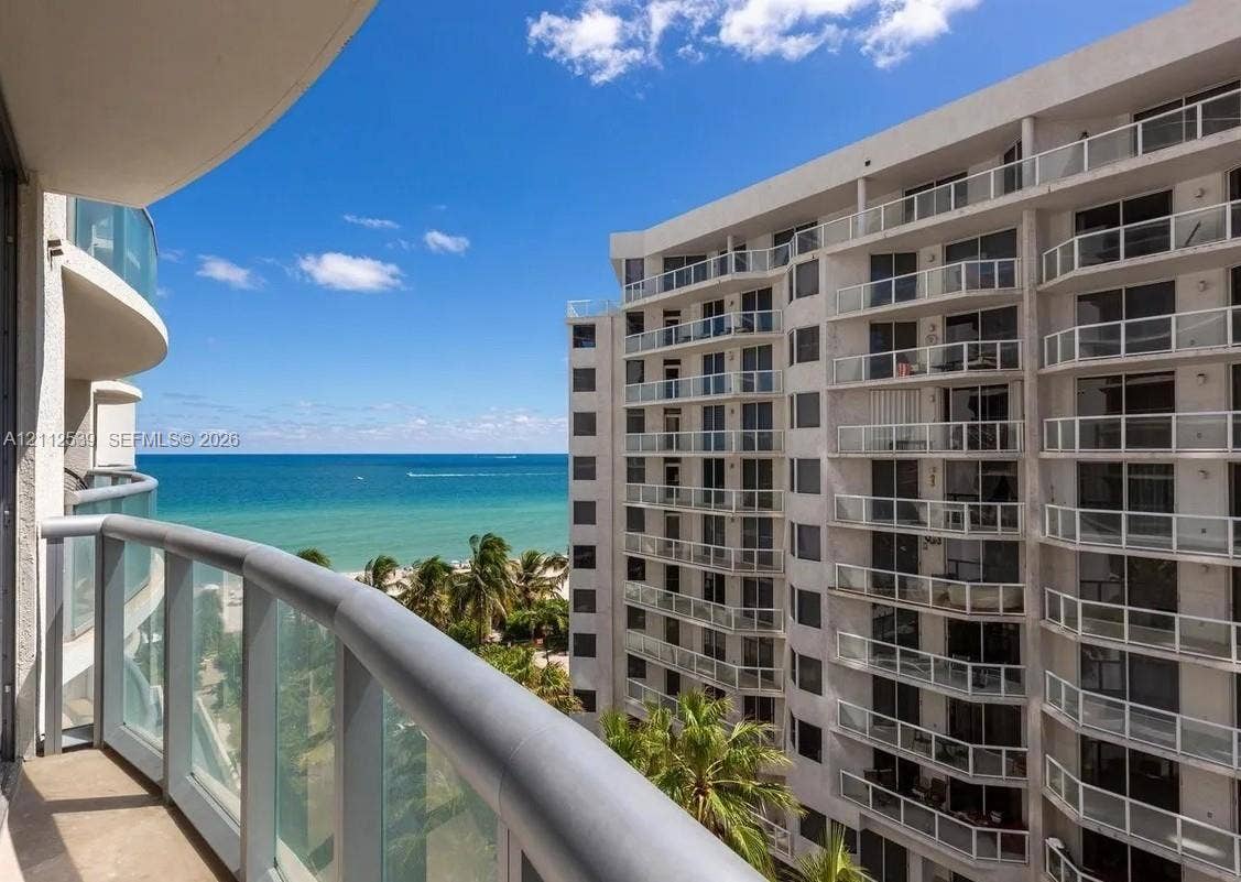 17315 Collins Avenue, #705, Sunny Isles Beach, FL 33160 Private balcony featuring metal railings and glass panels, overlooking oceanfront scenery and coastal palm trees