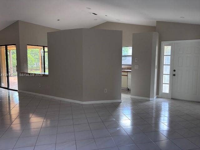 Vaulted ceilings with recessed lighting, large ceramic tile flooring, solid core entry door with sidelight, and sliding glass patio doors