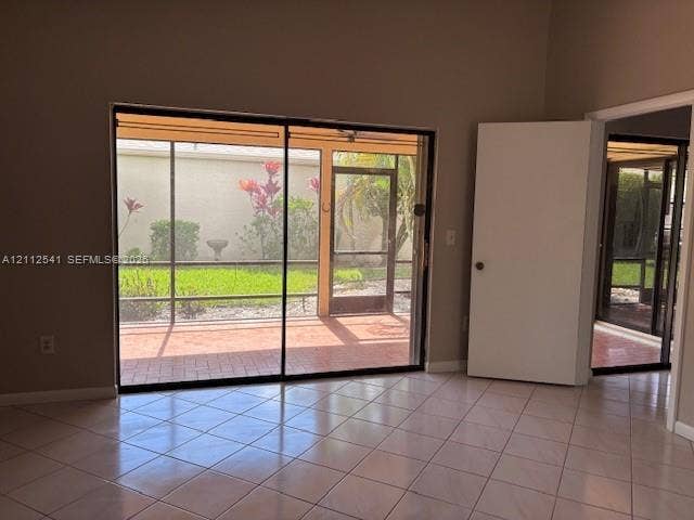 Interior space featuring ceramic tile flooring, large sliding glass doors, and a screened-in patio with brick-paver flooring