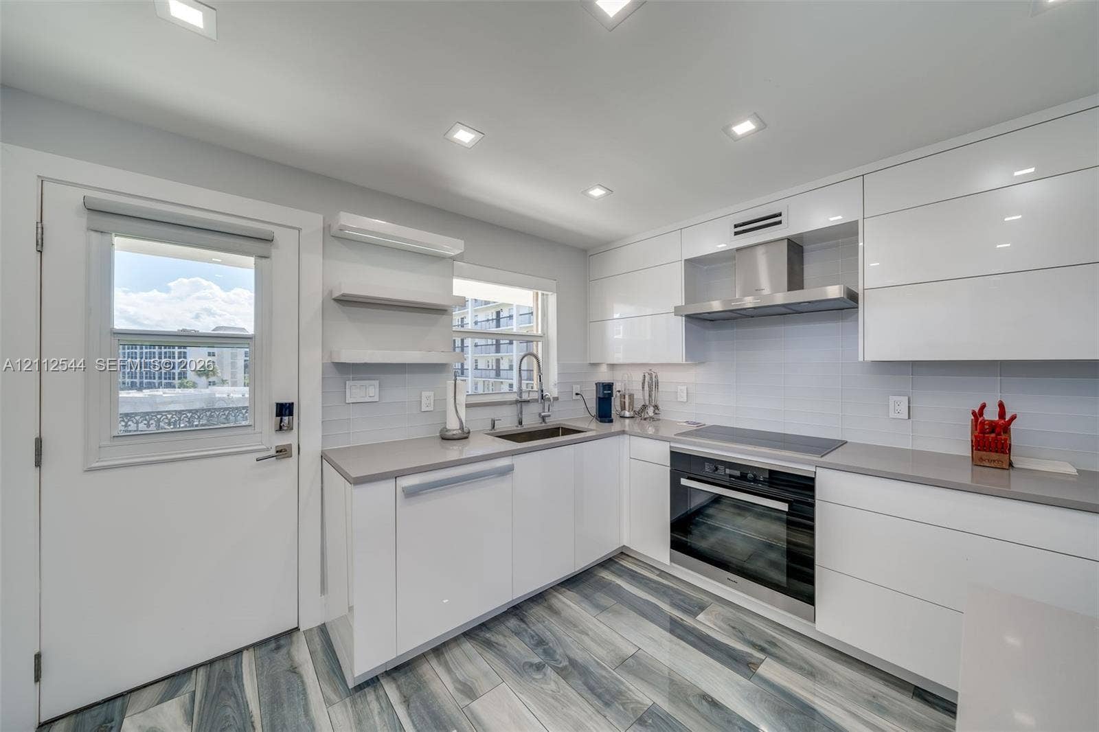 2871 N Ocean Boulevard, #R360, Boca Raton, Boca Raton, FL 33431 Kitchen featuring high-gloss white cabinetry, quartz countertops, stainless steel appliances, recessed lighting, and wood-finish tile flooring