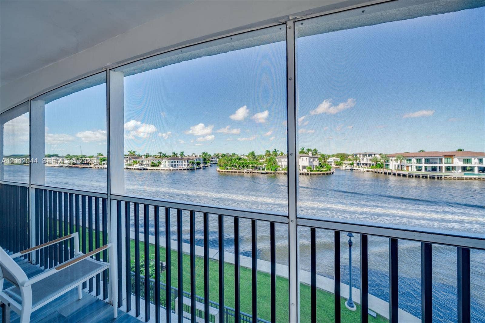 2871 N Ocean Boulevard, #R360, Boca Raton, Boca Raton, FL 33431 Screened-in balcony featuring black vertical railings, tile flooring, and waterfront scenery