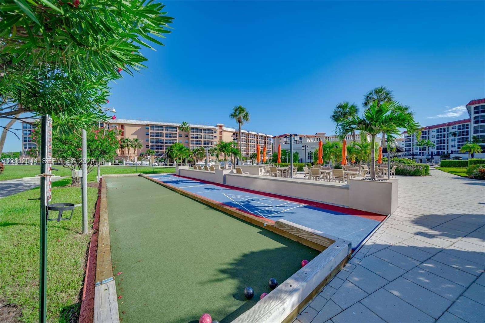 2871 N Ocean Boulevard, #R360, Boca Raton, Boca Raton, FL 33431 Outdoor recreation area featuring a bocce ball court, shuffleboard court, paved patio, and mature palm trees