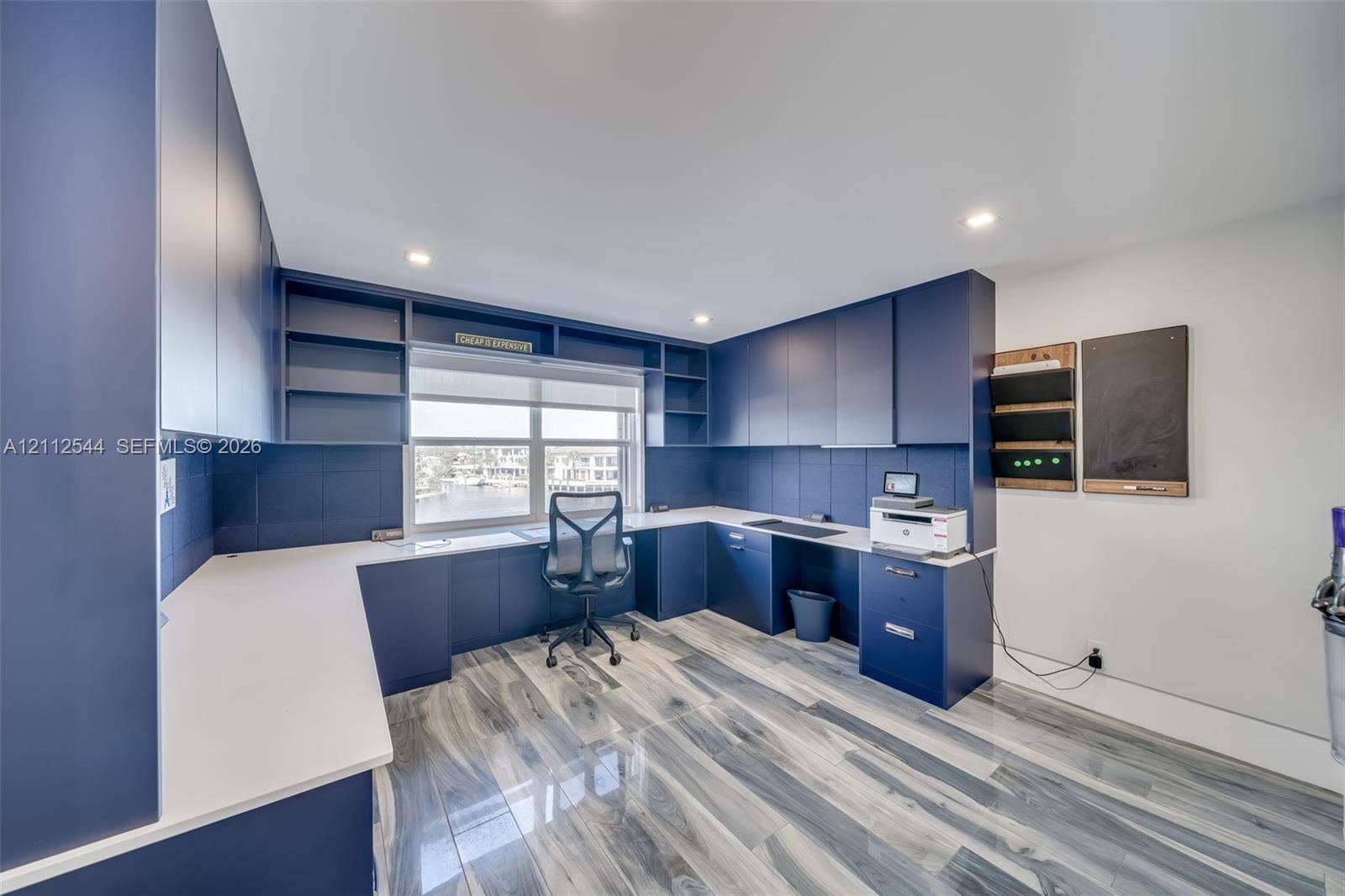 2871 N Ocean Boulevard, #R360, Boca Raton, Boca Raton, FL 33431 Custom built-in navy cabinetry with integrated shelving, white solid surface countertops, recessed ceiling lighting, and wood-finish flooring
