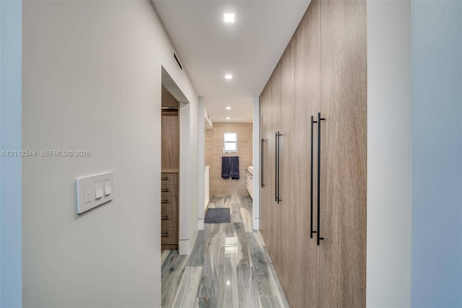 2871 N Ocean Boulevard, #R360, Boca Raton, Boca Raton, FL 33431 Floor-to-ceiling built-in wood-finish cabinetry featuring matte black hardware, recessed ceiling lighting, and porcelain tile flooring with a marble-pattern finish