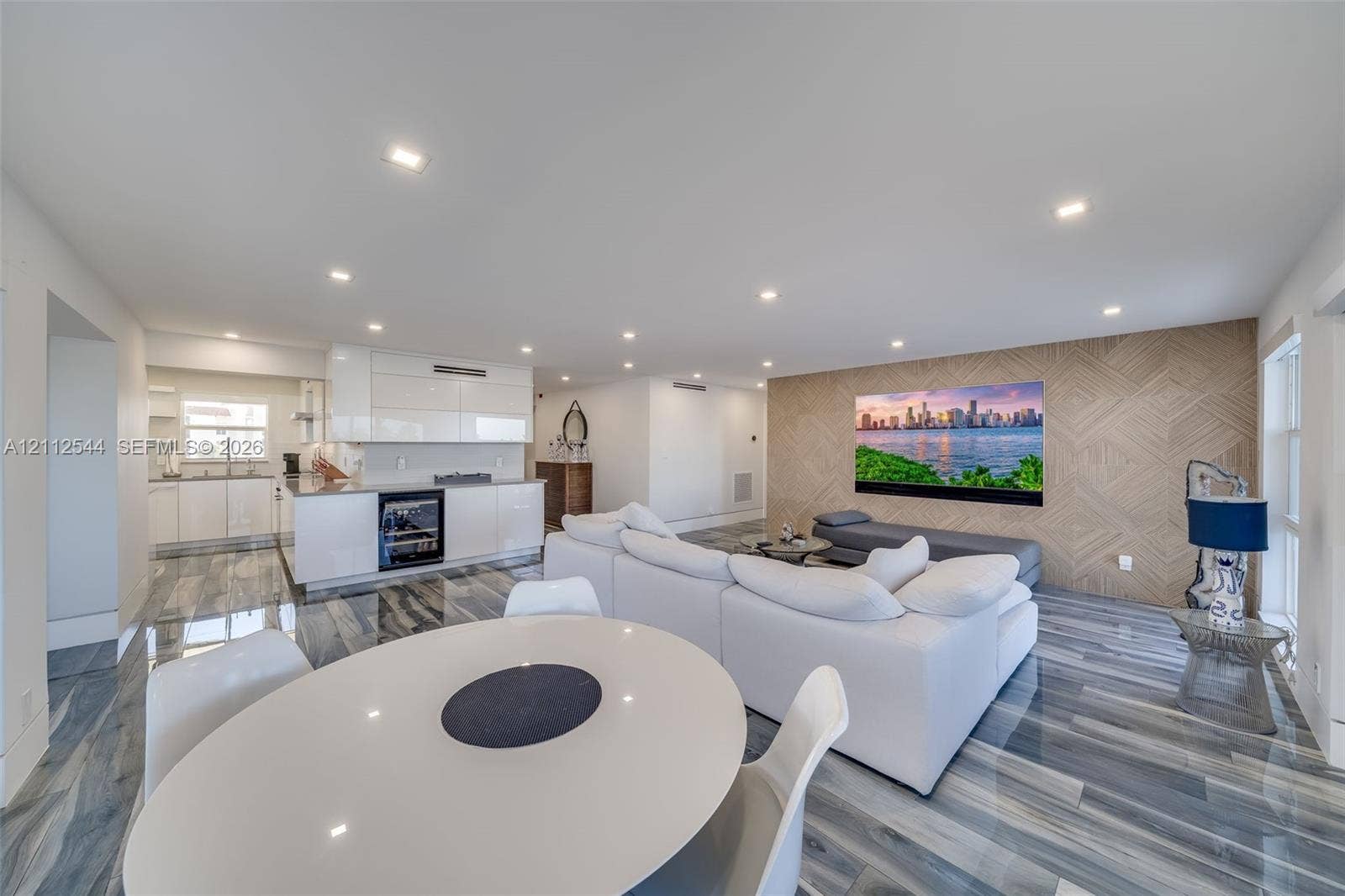 2871 N Ocean Boulevard, #R360, Boca Raton, Boca Raton, FL 33431 Open-concept space featuring polished stone-finish flooring, recessed lighting, glossy white cabinetry, built-in beverage refrigerator, and a decorative wood-paneled accent wall